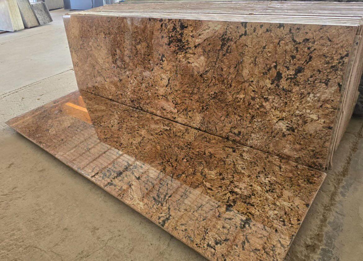 Polished golden granite slabs stacked at the Kisan Marble & Granite yard
